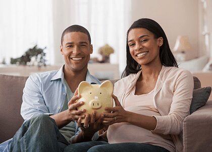 Couple holding yellow piggy bank