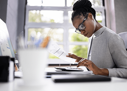 Professional woman using a calculator at her desk