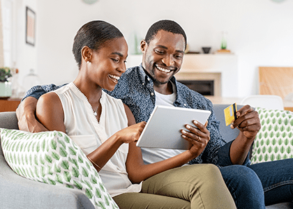 Couple looking at tablet on couch