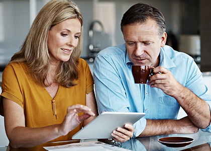 Couple drinking coffee and looking at tablet