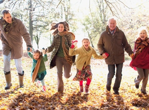 Family running through fall leaves